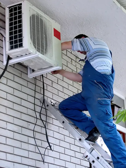 técnico realizando una revision a un condesandor de aire